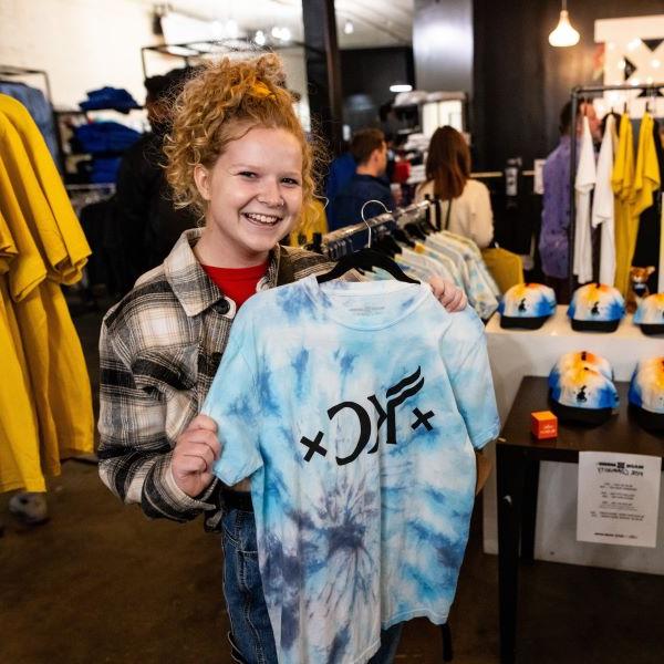 A UMKC student shows off a tie-dye UMKC Roos Mobb t-shirt at Made Mobb at the 2023 Crossroads Arts District pop-up event.